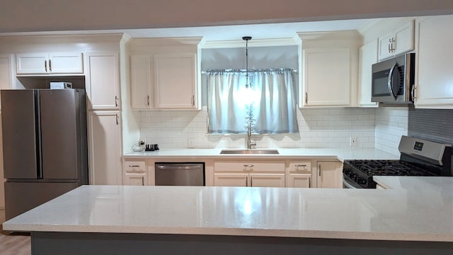 kitchen featuring white cabinets, decorative light fixtures, stainless steel appliances, and sink