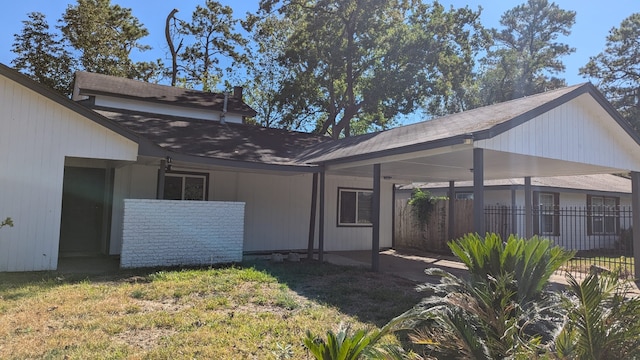 back of property with a yard and a carport