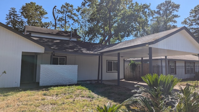 rear view of property with a yard and a carport