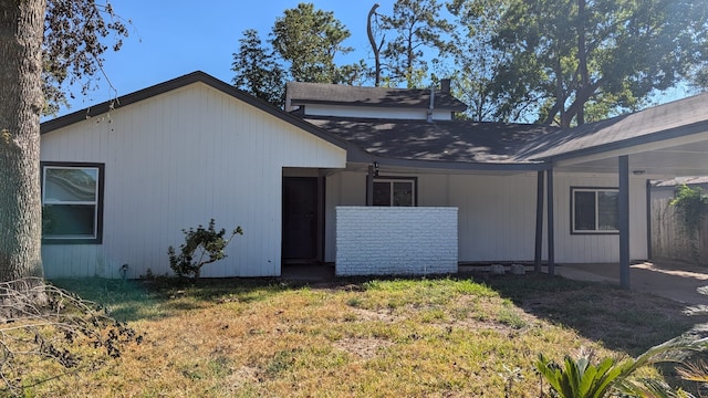 rear view of property featuring a lawn