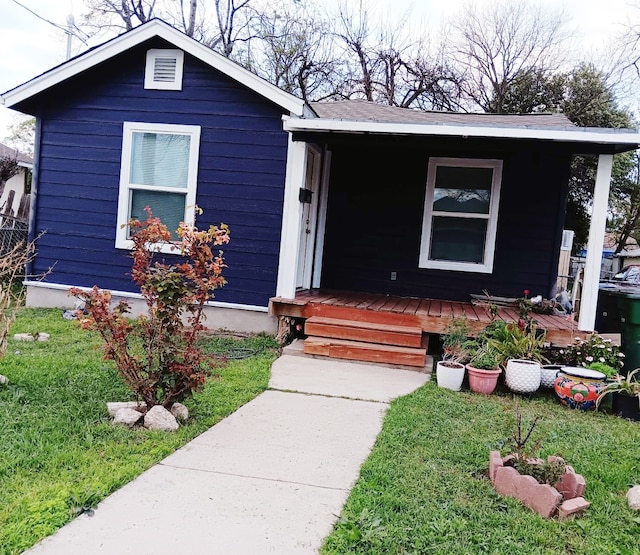 view of front of house featuring covered porch and a front lawn