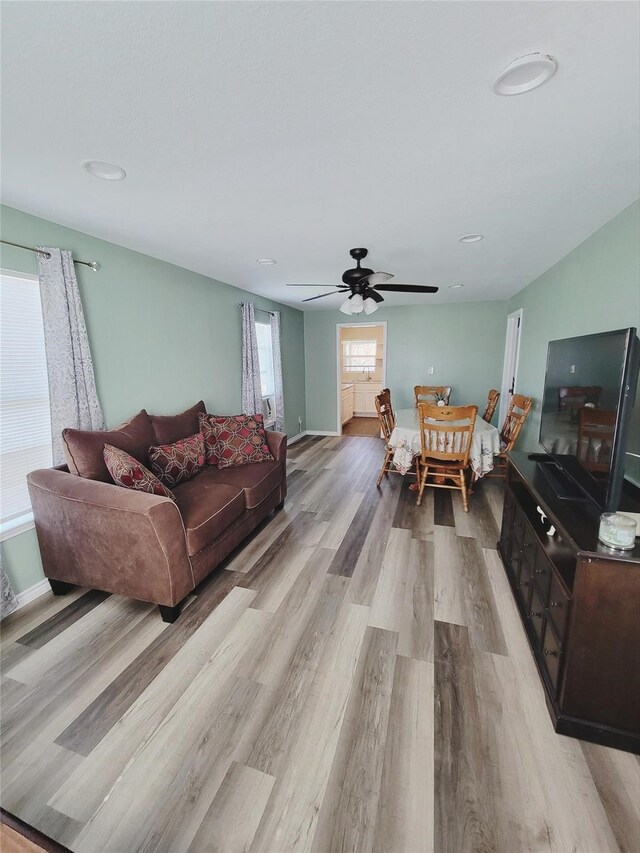 living room featuring light wood-type flooring and ceiling fan