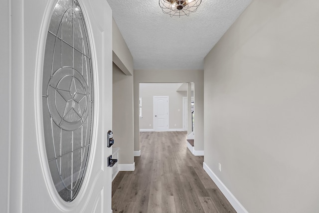 entrance foyer featuring a textured ceiling and light wood-type flooring