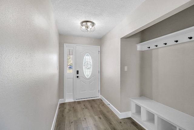 mudroom featuring light wood-type flooring and a textured ceiling