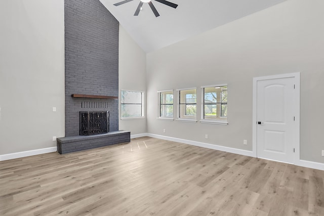 unfurnished living room featuring a brick fireplace, ceiling fan, light hardwood / wood-style flooring, and high vaulted ceiling