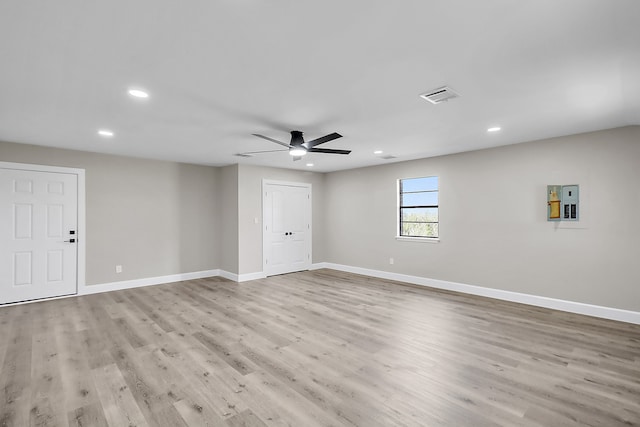 spare room with light wood-type flooring, electric panel, and ceiling fan