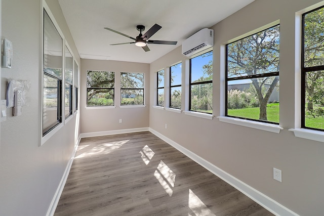 unfurnished sunroom featuring ceiling fan, a wealth of natural light, and a wall mounted AC