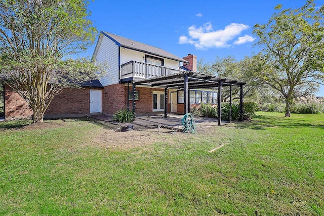 rear view of house featuring a lawn and a patio