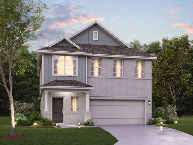 view of front of home with a yard and a garage