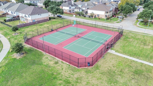 view of tennis court featuring a lawn