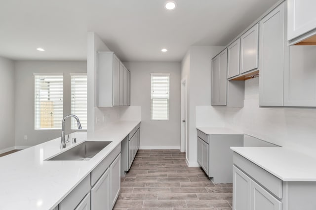 kitchen with light hardwood / wood-style floors, decorative backsplash, and sink