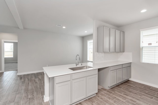 kitchen featuring a wealth of natural light, sink, and kitchen peninsula