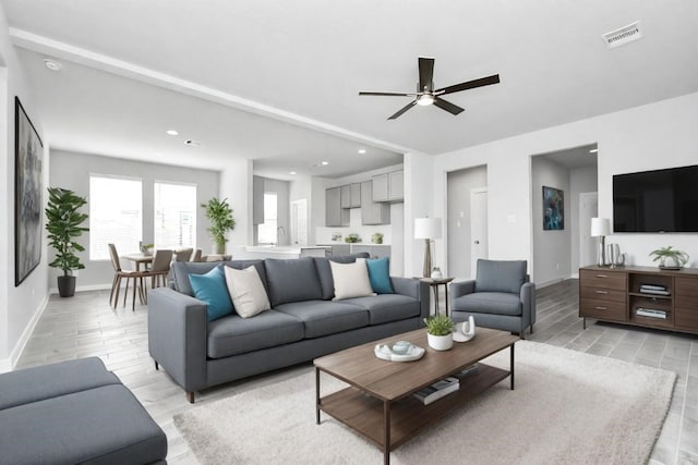 living room featuring light hardwood / wood-style flooring and ceiling fan