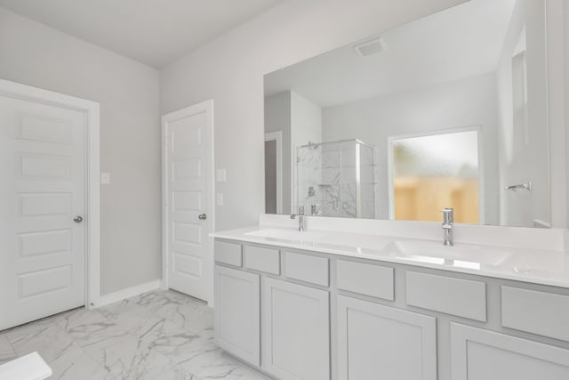 bathroom featuring a shower with door and vanity