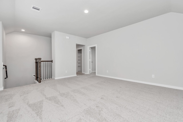 spare room featuring lofted ceiling and light colored carpet