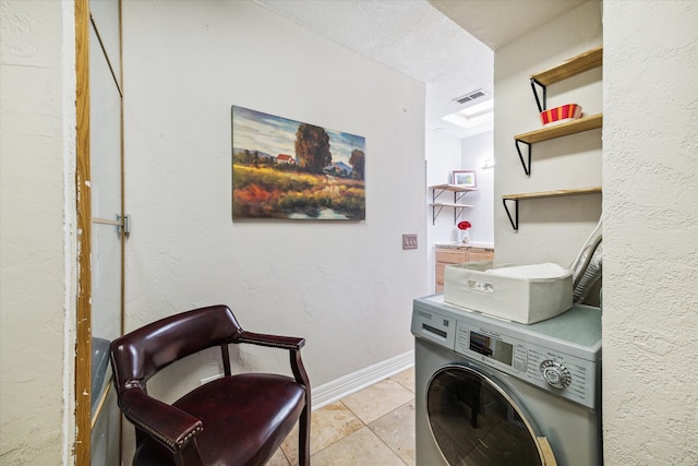 washroom featuring washer / clothes dryer, a textured ceiling, and light tile patterned floors