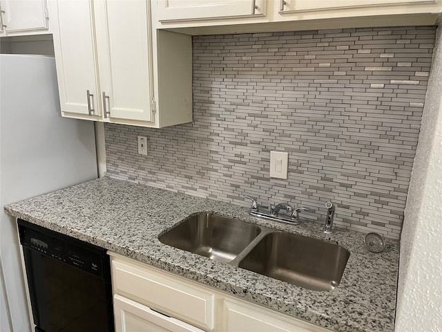 kitchen with decorative backsplash, white cabinetry, light stone countertops, black appliances, and sink