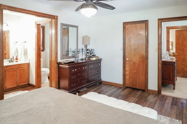 bedroom with connected bathroom, ceiling fan, sink, and dark hardwood / wood-style floors