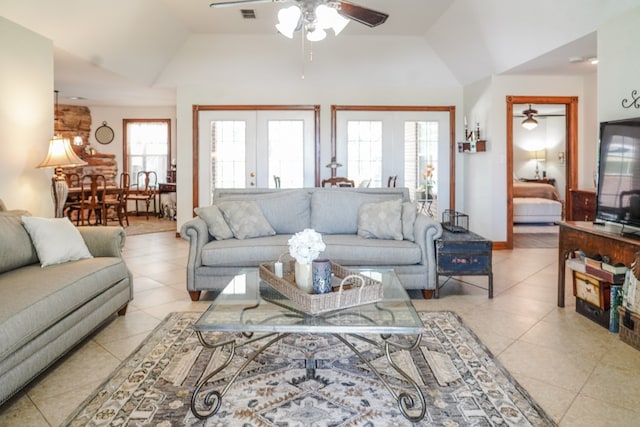 living room featuring french doors, light tile patterned floors, vaulted ceiling, and ceiling fan