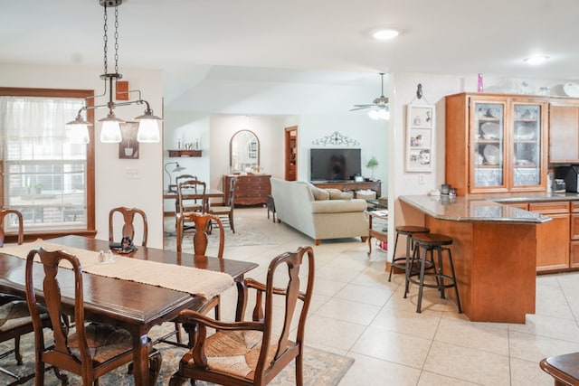 dining area with lofted ceiling, light tile patterned floors, and ceiling fan