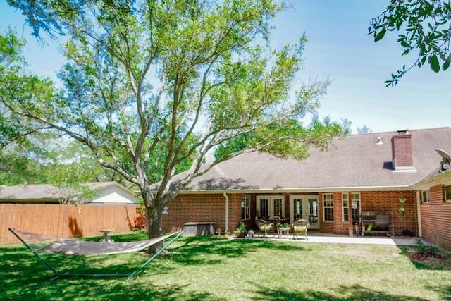 rear view of property with a yard and a patio