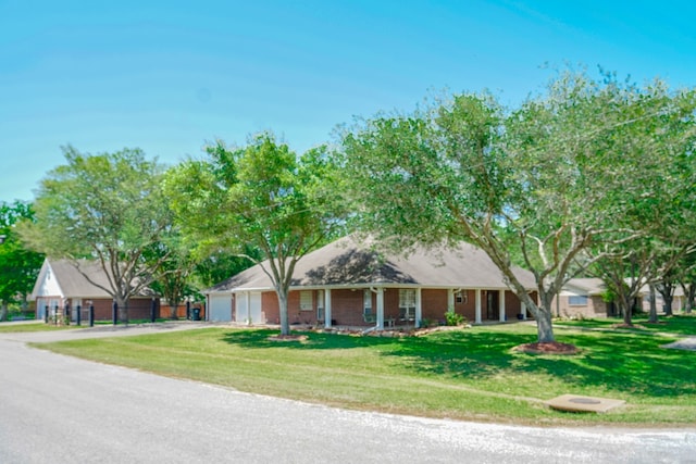 ranch-style house featuring covered porch, a garage, and a front lawn