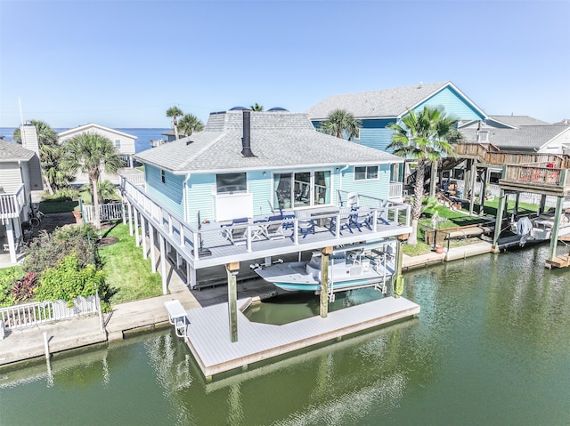 rear view of house featuring a deck with water view