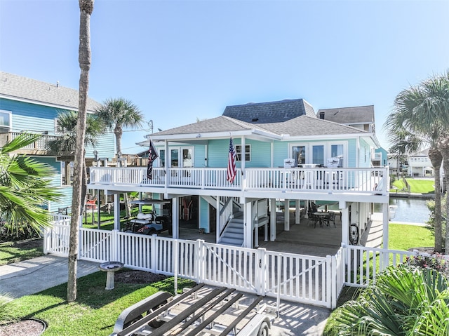 view of front of home featuring a carport, a deck with water view, and a front lawn