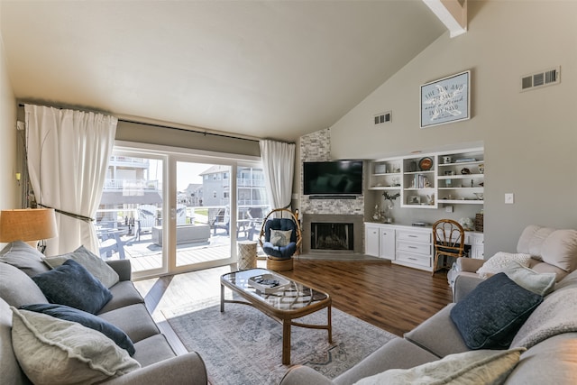 living room featuring wood-type flooring, high vaulted ceiling, a stone fireplace, and beam ceiling