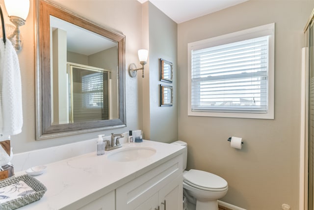 bathroom featuring vanity, toilet, and walk in shower