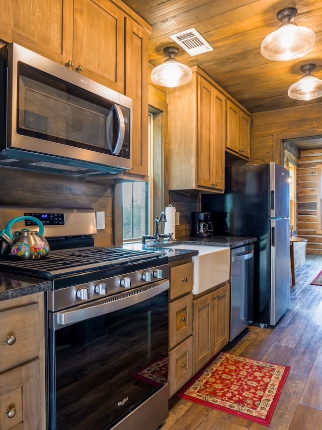 kitchen featuring dark wood-type flooring, stainless steel appliances, wooden ceiling, and wooden walls