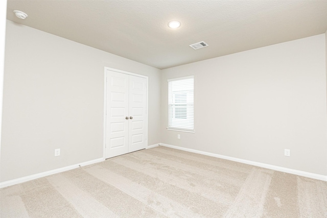 carpeted spare room featuring a textured ceiling