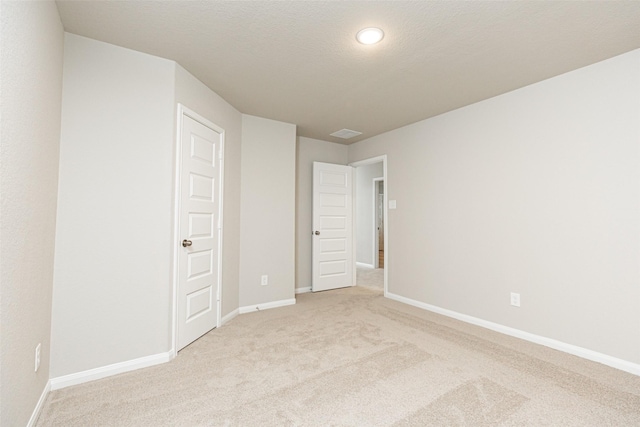 carpeted empty room with a textured ceiling