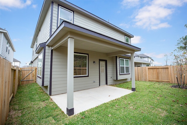 rear view of property with a lawn and a patio area