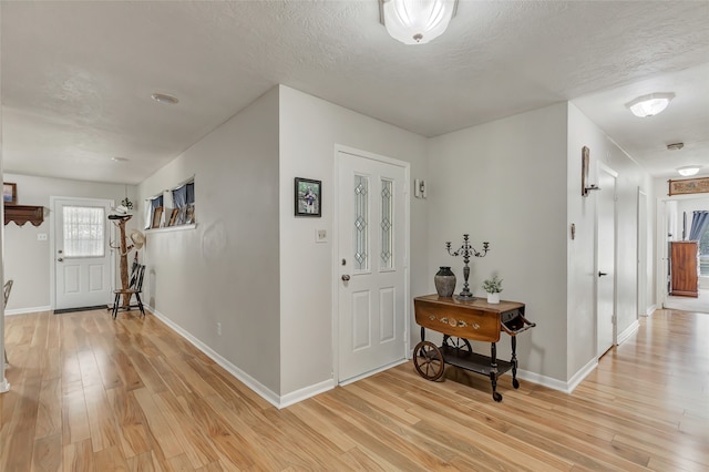 entryway with light hardwood / wood-style flooring and a textured ceiling