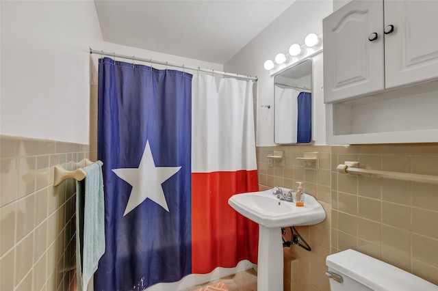 bathroom featuring tile walls, toilet, and walk in shower