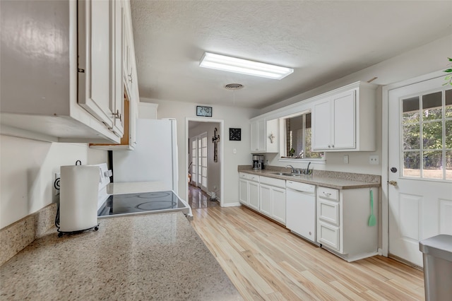 kitchen with white appliances, white cabinetry, sink, and light wood-type flooring