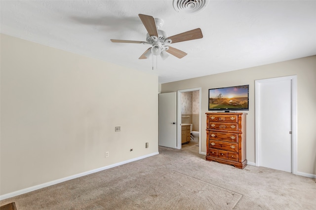 unfurnished bedroom with ensuite bathroom, light colored carpet, and ceiling fan