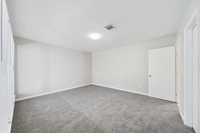 unfurnished room featuring dark carpet