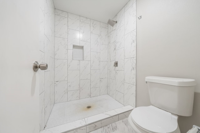 bathroom with tiled shower and toilet