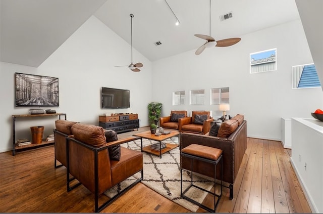 living room featuring hardwood / wood-style floors, rail lighting, high vaulted ceiling, and ceiling fan