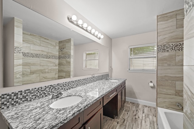 bathroom with vanity, tiled shower / bath combo, and wood-type flooring