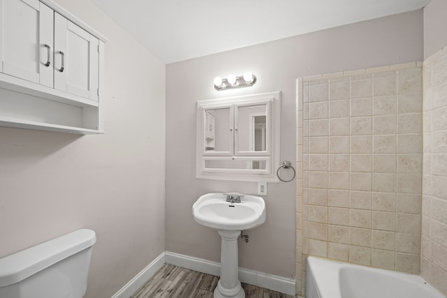 bathroom with hardwood / wood-style flooring and toilet