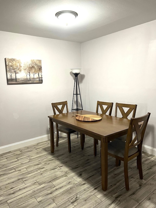 dining space featuring a textured ceiling and wood-type flooring