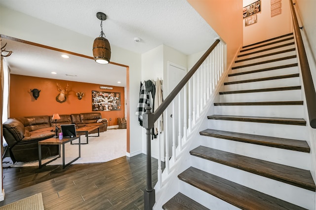 stairway featuring a textured ceiling and wood-type flooring