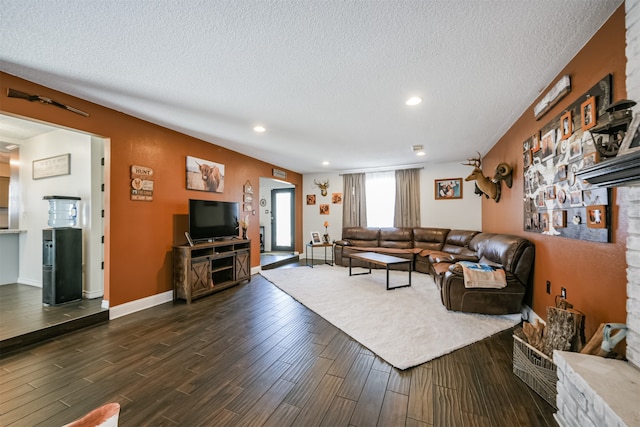 living room with a textured ceiling and dark hardwood / wood-style floors