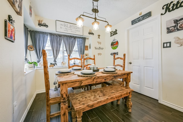 dining room with a textured ceiling and dark hardwood / wood-style flooring