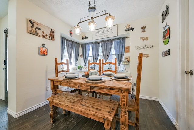 dining area featuring an inviting chandelier, a textured ceiling, and dark wood-type flooring