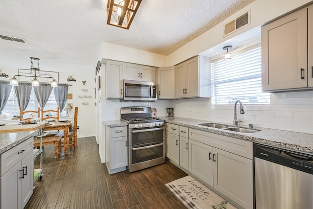 kitchen featuring a textured ceiling, dark hardwood / wood-style floors, sink, gray cabinetry, and stainless steel appliances