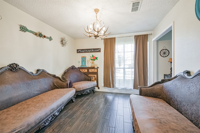 sitting room featuring a textured ceiling, an inviting chandelier, and dark hardwood / wood-style flooring